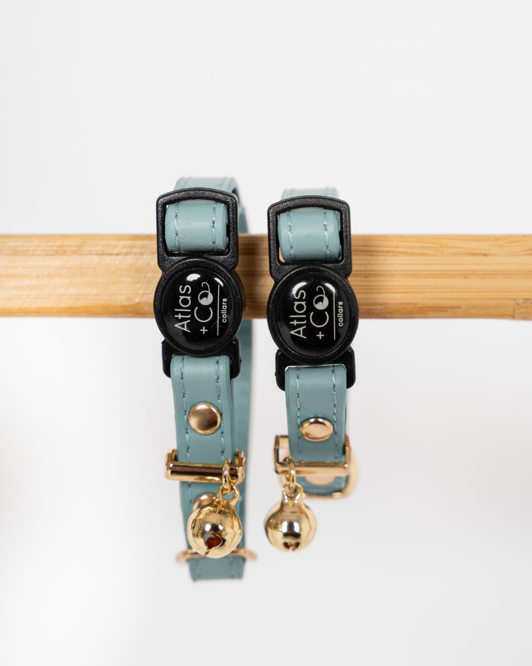 Two teal cat collars with gold charms on a white background #colour_cove