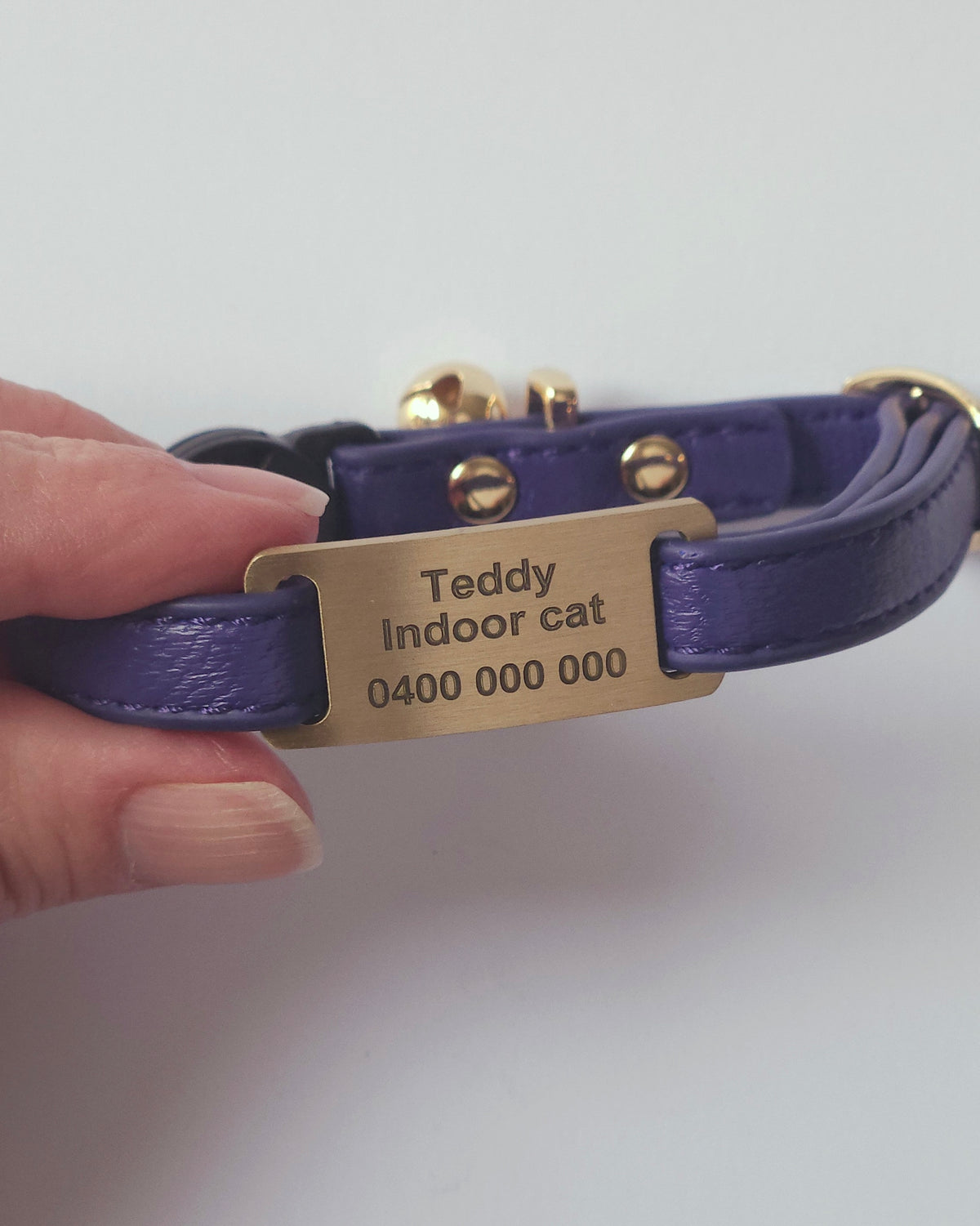brass id tag on a purple cat collar #shape_slide
